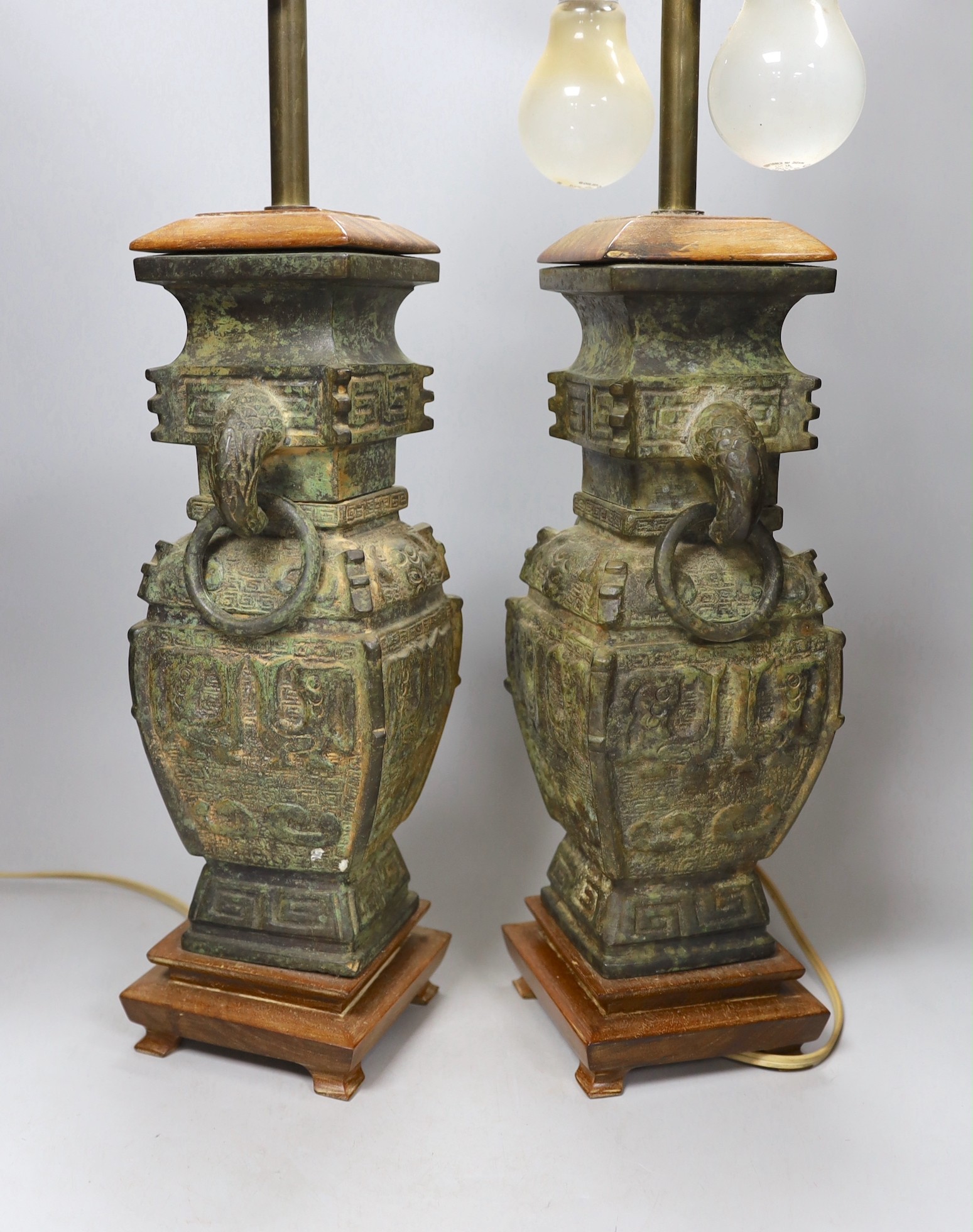 A pair of archaic Chinese bronze vases, converted into table lamps, 62cms high including light fitting